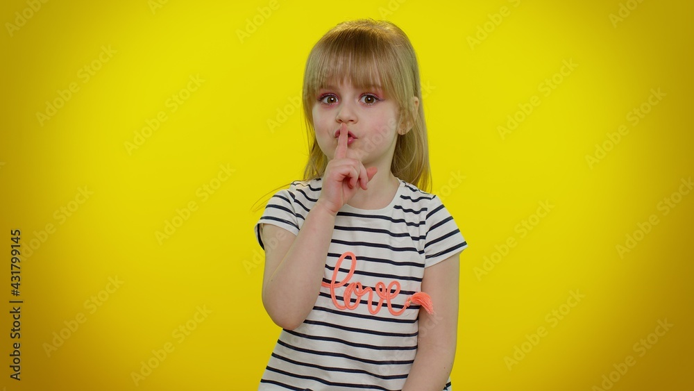 Shh be quiet please. Portrait of funny blonde child girl 5-6 years old presses index finger to lips makes silence gesture sign do not tells secret on yellow studio wall background. Teen kid children Shh be quiet please. Portrait of funny blonde child girl 5-6 years old presses index finger to lips makes silence gesture sign do not tells secret on yellow studio wall background. Teen kid children