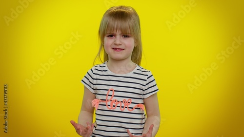 Quarrel. Displeased blonde child girl 5-6 years old gesturing hands with irritation and displeasure, blaming scolding for failure, asking why this happened on yellow wall background. Teen kid children