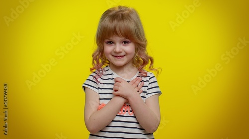 I am not guilty. Portrait of blonde kid child 5-6 years old pointing fingers himself ask say who me no thanks i do not need it. Yellow studio wall background. Teenager children girl lifestyle emotions
