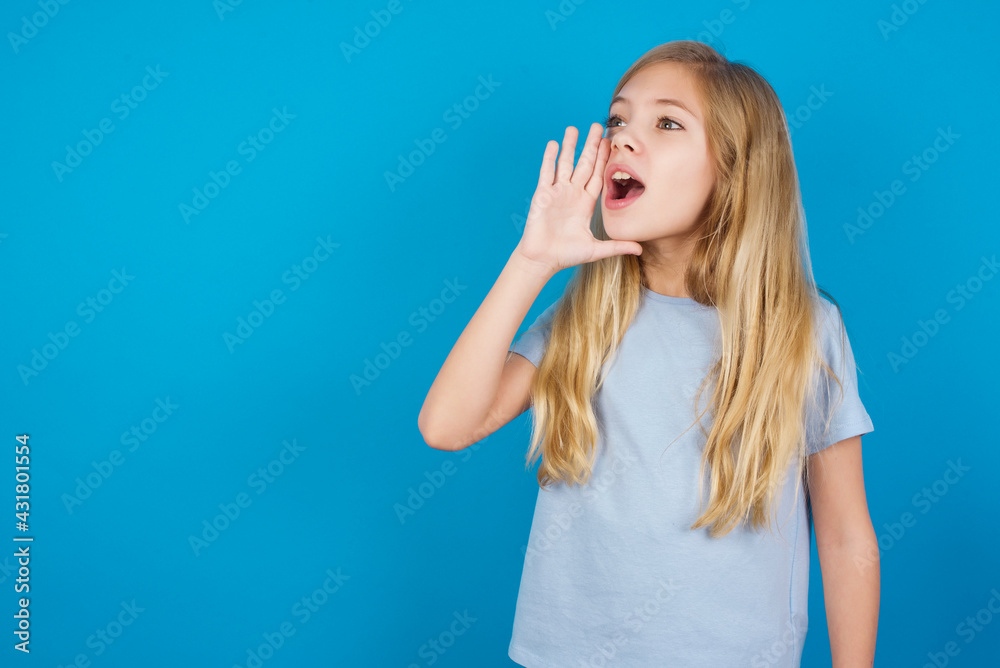 beautiful Caucasian little girl wearing blue T-shirt over blue background profile view, looking happy and excited, shouting and calling to copy space. beautiful Caucasian little girl wearing blue T-shirt over blue background profile view, looking happy and excited, shouting and calling to copy space.