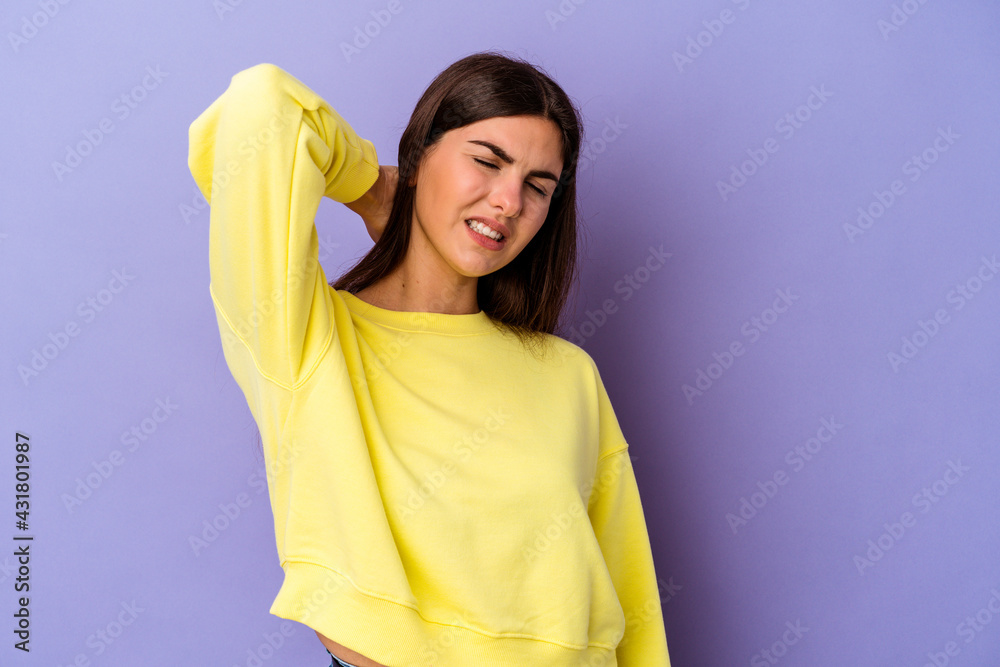 Young caucasian woman isolated on purple background suffering neck pain due to sedentary lifestyle. Young caucasian woman isolated on purple background suffering neck pain due to sedentary lifestyle.