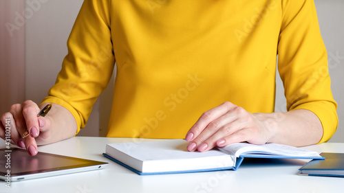 a woman writes down information with a pen in a diary