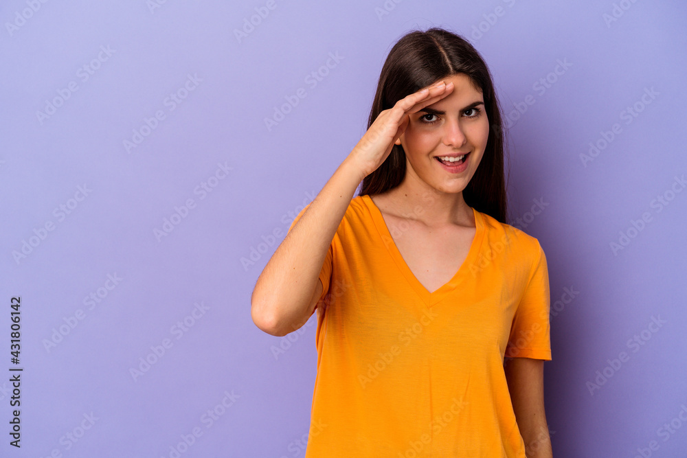 Young caucasian woman isolated on purple background shouts loud, keeps eyes opened and hands tense. Young caucasian woman isolated on purple background shouts loud, keeps eyes opened and hands tense.