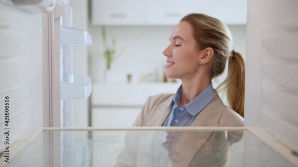 Woman in suit looks into an empty refrigerator, but the problem can be solved! Online ordering of goods from the supermarket. Animation of the appearance of goods. View from inside fridge Woman in suit looks into an empty refrigerator, but the problem can be solved! Online ordering of goods from the supermarket. Animation of the appearance of goods. View from inside fridge