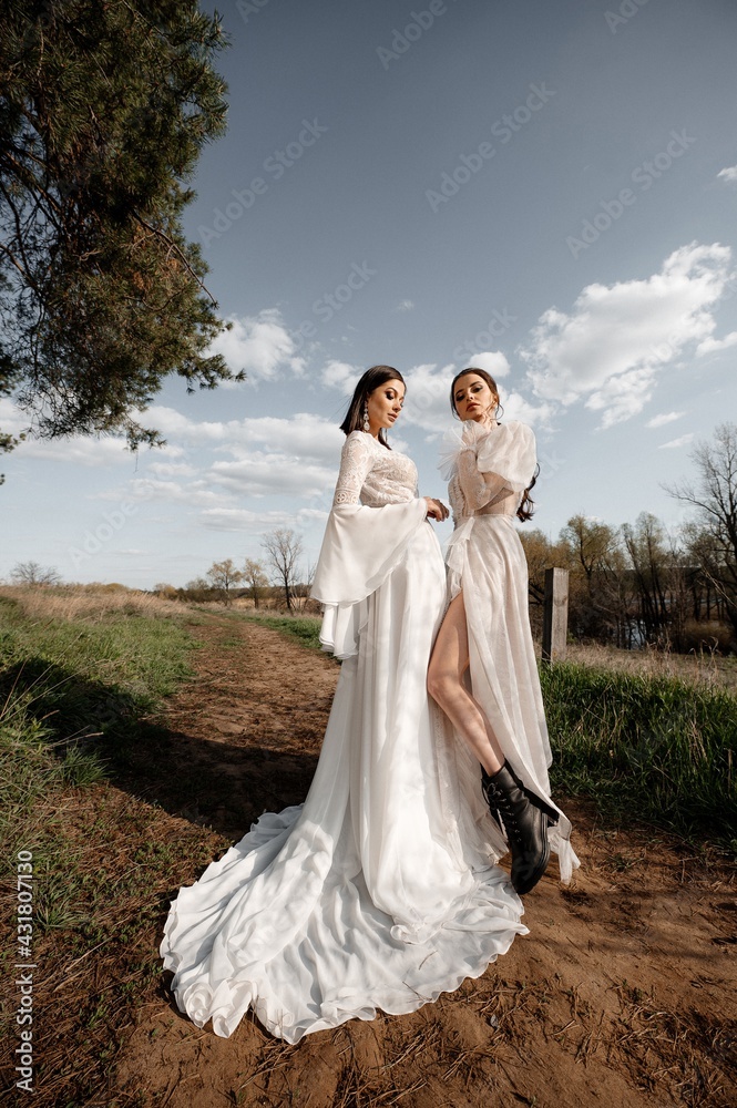 Two beautiful brides in a light dress posing. Boho style. 