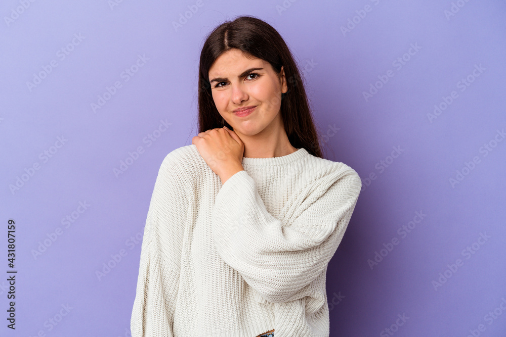 Young caucasian woman isolated on purple background having a shoulder pain. Young caucasian woman isolated on purple background having a shoulder pain.