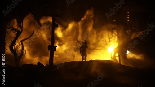 Silhouette soldier carrying little boy on his shoulder from fire. Rescue savior concept. Man moving out with little boy from burned out city destroyed in war. Selective focus