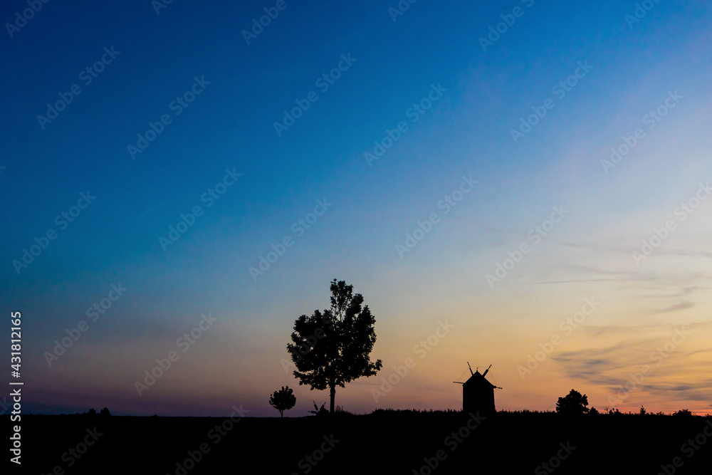 an old windmill silhouette at sunset, windmills of Tes at sunset