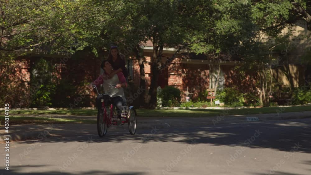 Cute couple in residential suburb riding on tricycle together. Cute couple in residential suburb riding on tricycle together.