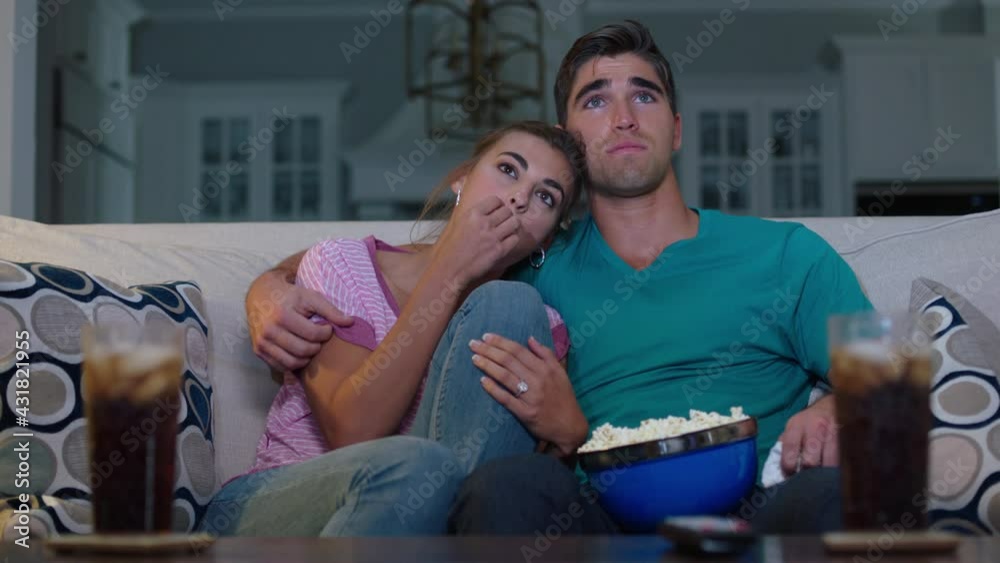 Girlfriend teasing her partner as her tears up while watching movie at home together Girlfriend teasing her partner as her tears up while watching movie at home together