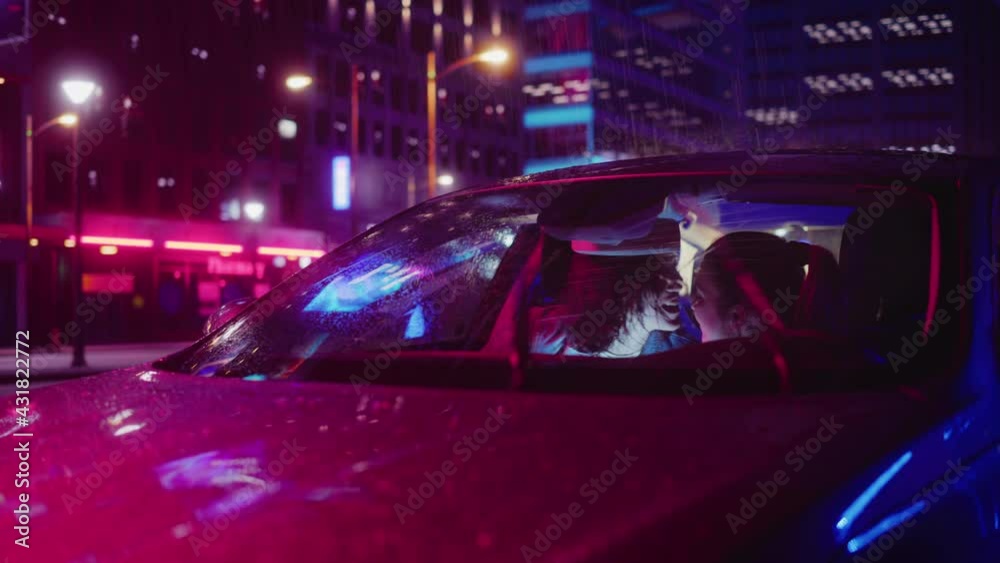 Young Female Picking Up Her Girlfriend, Couple Kiss in Romantic Fashion, Smile on Rainy Night in the City. Women in Love on a Date in Neon Urban Environment. Concept of LGBT, Relations and Diversity. Young Female Picking Up Her Girlfriend, Couple Kiss in Romantic Fashion, Smile on Rainy Night in the City. Women in Love on a Date in Neon Urban Environment. Concept of LGBT, Relations and Diversity.