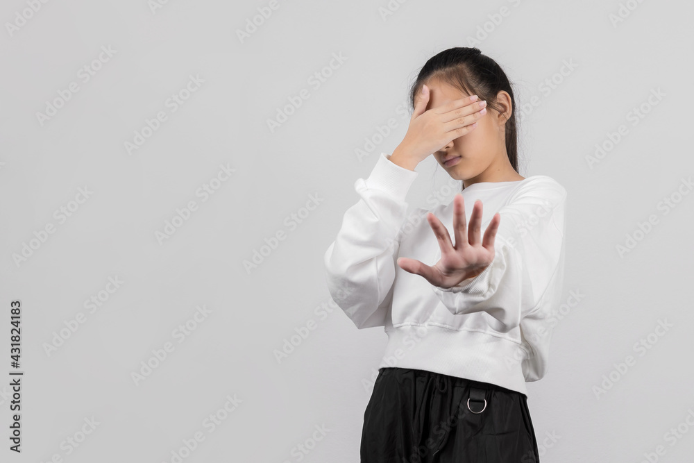 Cute little girl on gray background covering eyes with hands and doing stop gesture with sad and fear expression. Embarrassed and negative Cute little girl on gray background covering eyes with hands and doing stop gesture with sad and fear expression. Embarrassed and negative