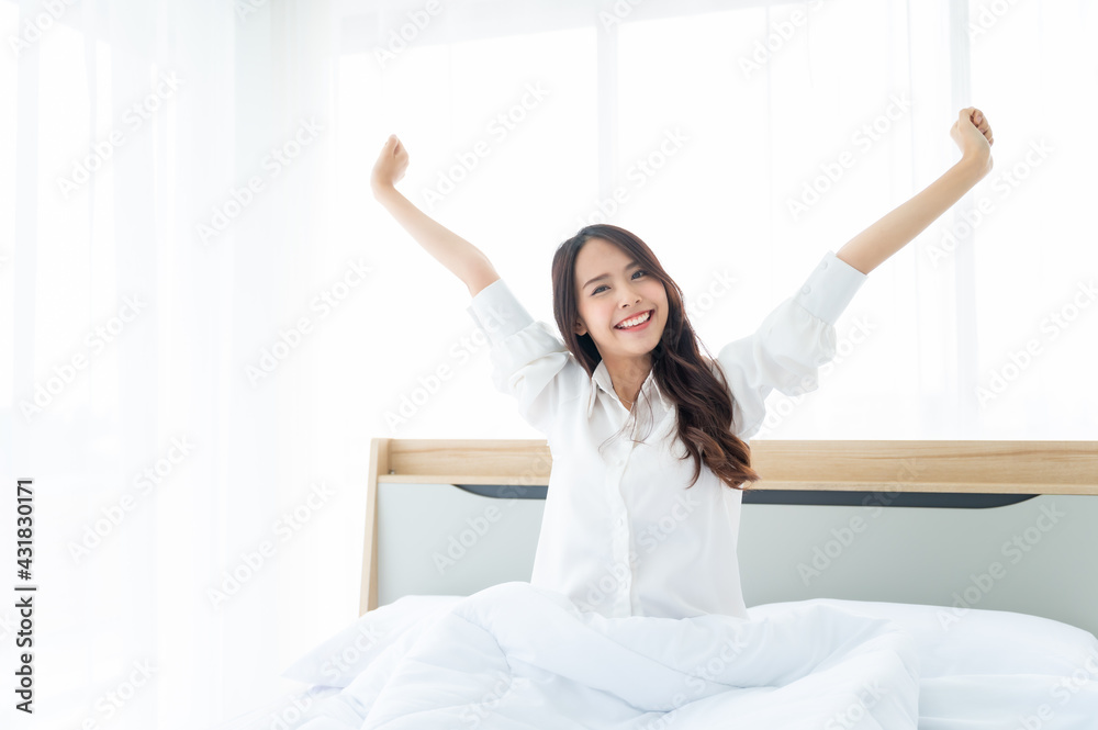 Beautiful women asian wake up in morning in bedroom. She clothing white dress stretching body and feeling fresh Beautiful women asian wake up in morning in bedroom. She clothing white dress stretching body and feeling fresh
