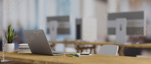 3D rendering, computer laptop on wooden table with stationery, supplies and plant pot in blurred office room background