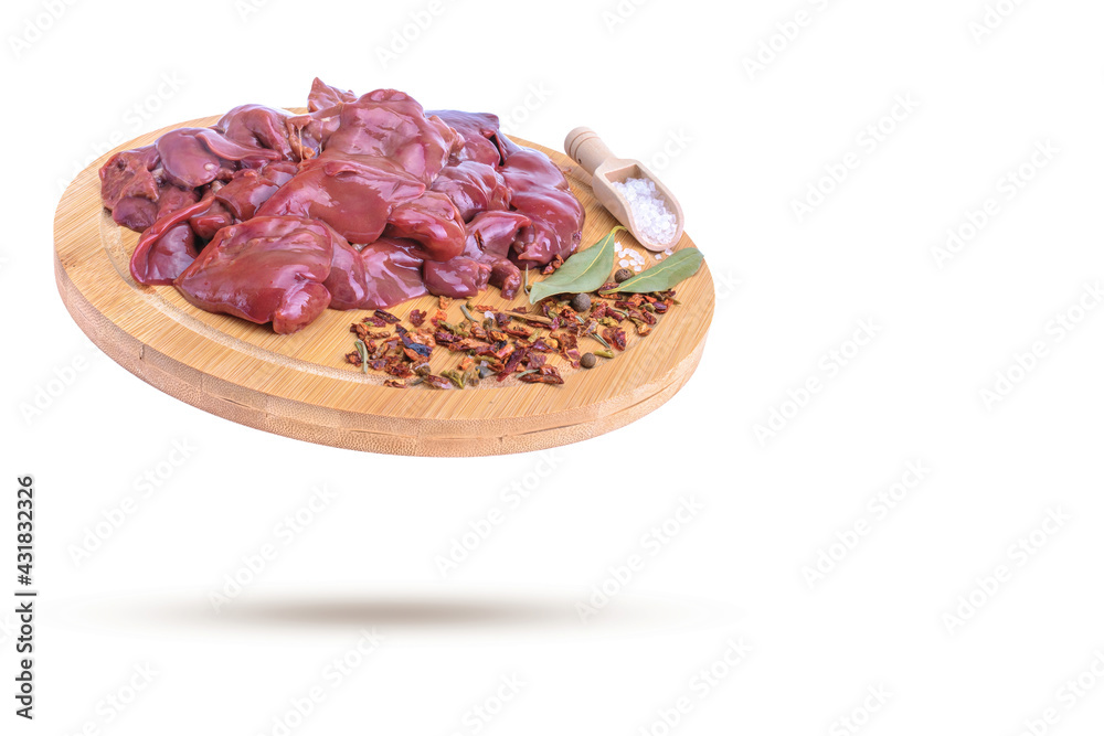 raw chicken liver with spices on a round wooden cutting board close-up isolated on a white background