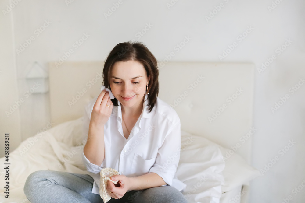 Cute caucasian girl woman holding reusable cotton pads in her hands, girl in a real bedroom interior, concept of ecology and conscious consumption Cute caucasian girl woman holding reusable cotton pads in her hands, girl in a real bedroom interior, concept of ecology and conscious consumption
