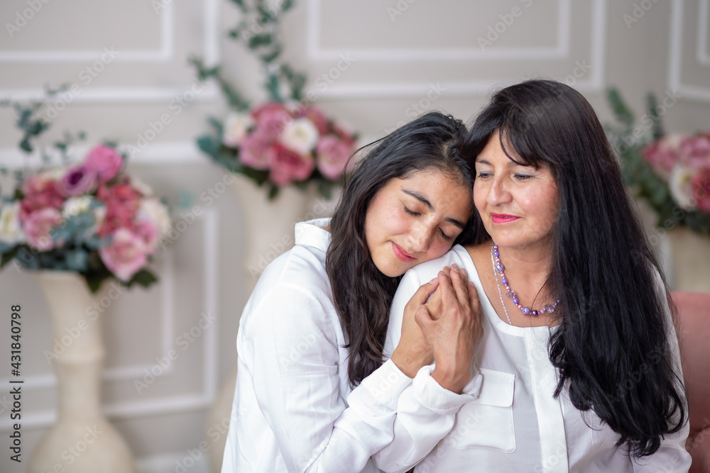Mexican mother and daughter hugging on mother's day Mexican mother and daughter hugging on mother's day