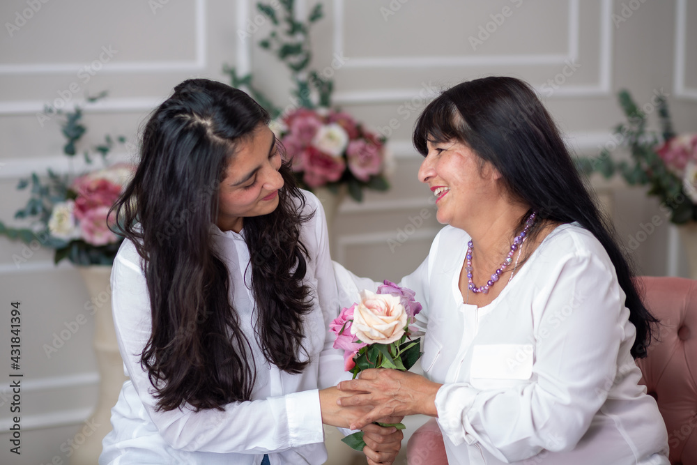 Mexican daughter delivering flowers to her mother on mother's day Mexican daughter delivering flowers to her mother on mother's day