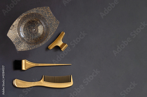 Obraz na plátně Golden hairdressing tools for hair coloring on a dark gray background with copy space
