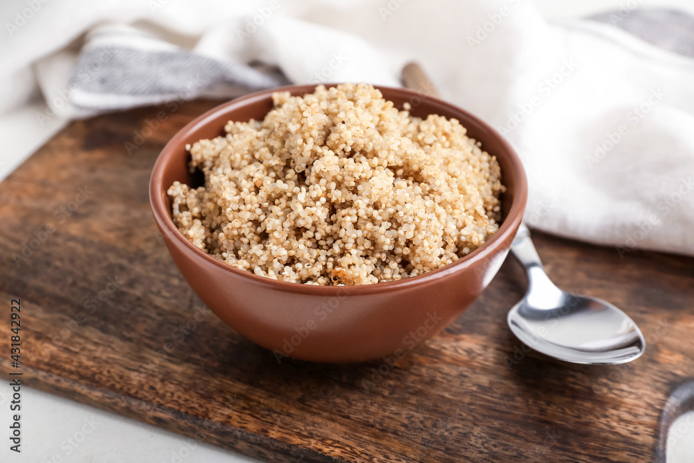 Bowl with tasty quinoa and spoon on table Bowl with tasty quinoa and spoon on table