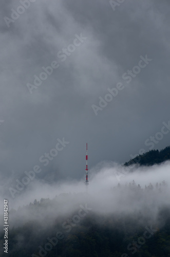 Clouds surrounding an antena in the mountain