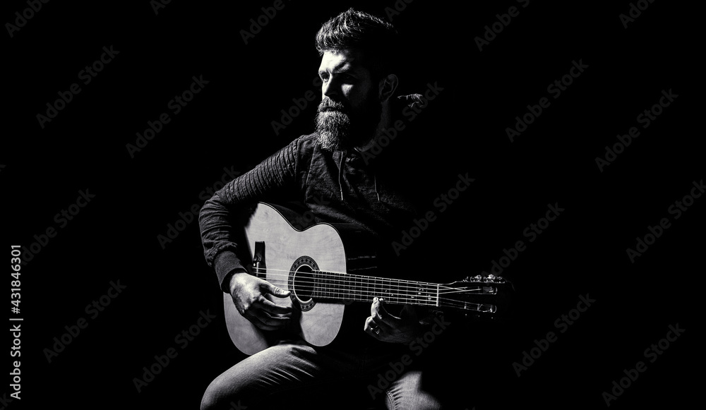 Bearded guitarist plays. Play the guitar. Beard hipster man sitting in a pub. Guitars and strings. Bearded man playing guitar, holding an acoustic guitar in his hands. Music concept. Black and white - obrazy, fototapety, plakaty 