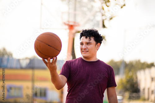 Man on basketball court holding ball. © liderina