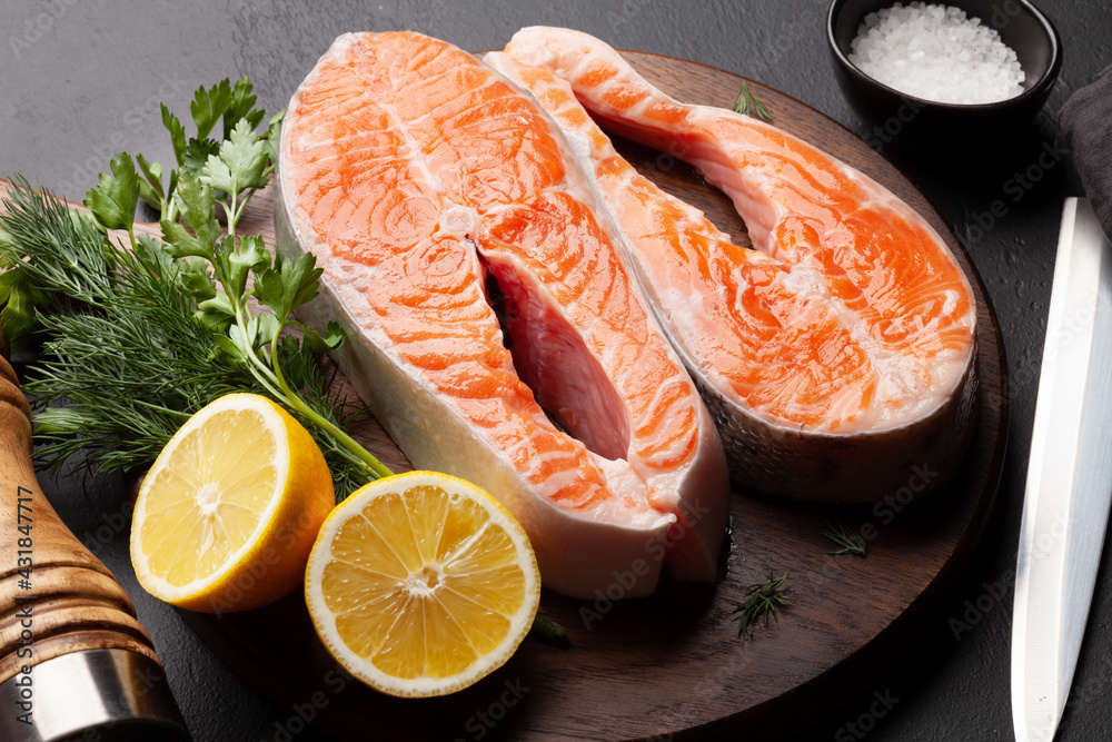 Fresh raw salmon cooking. Fish steaks with herbs and spices Fresh raw salmon cooking. Fish steaks with herbs and spices