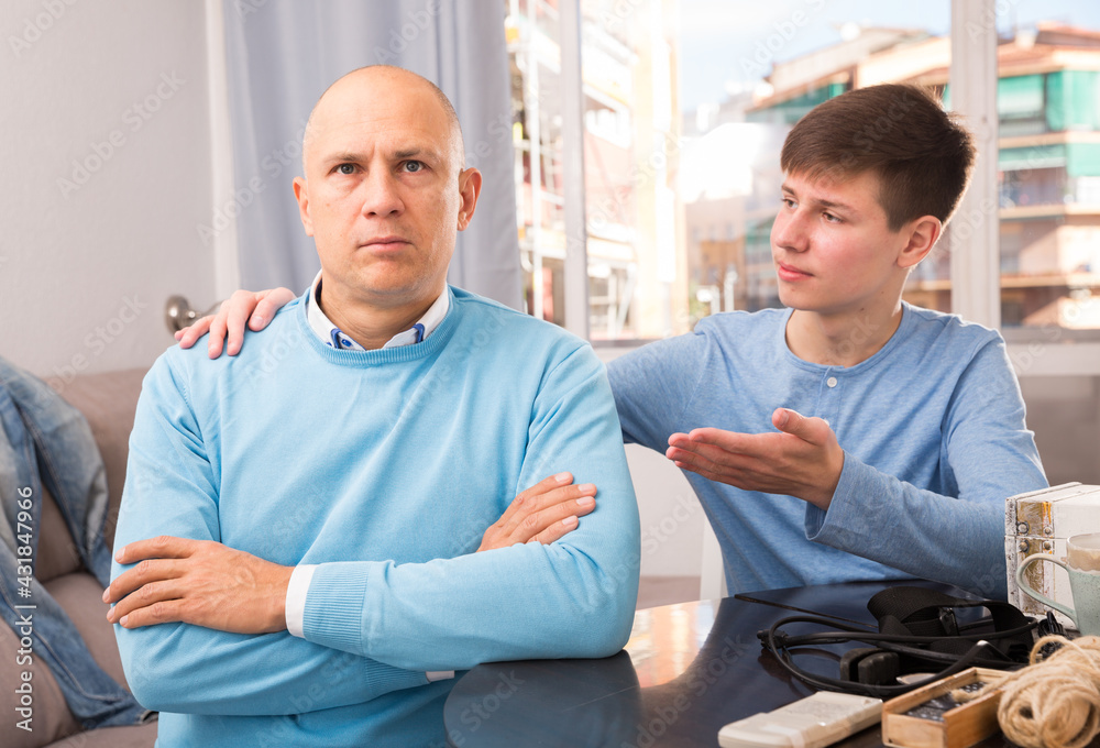 Obraz premium Teenage son asking for forgiveness from his offended father