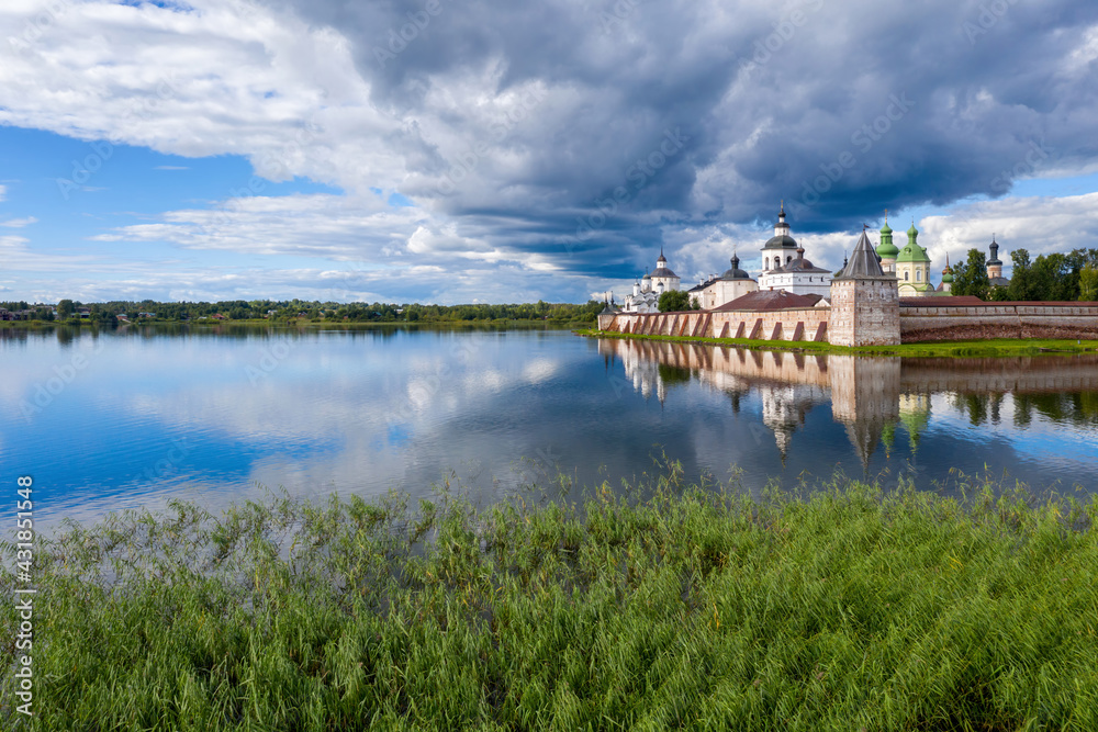 Fototapeta premium View of Kirillo-Belozersky Monastery and lake Siverskoye on sunny summer day with dramatic clouds. Kirillov, Vologda Oblast, Russia.