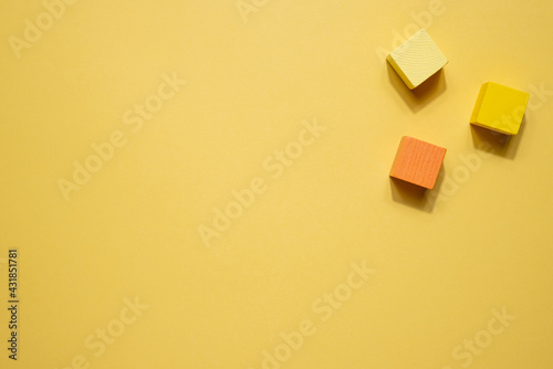 Yellow geometrical figures still life composition. Wooden game cube objects on yellow background. Platonic solids figures, simplicity concept