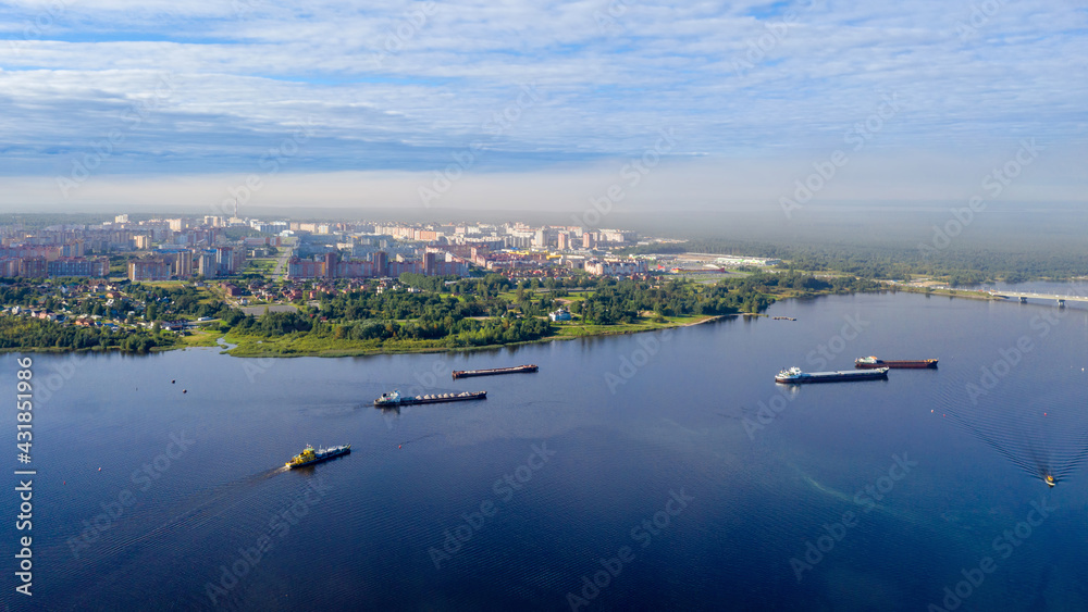 Aerial view of barges on Sheksna river on sunny summer day. Cherepovets, Vologda Oblast, Russia. Aerial view of barges on Sheksna river on sunny summer day. Cherepovets, Vologda Oblast, Russia.