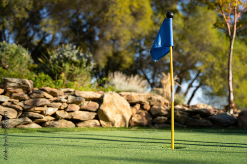 Blue golf flag on a miniature golf putting green