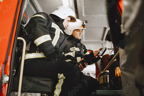 Firefighters in a fire truck look at tablet