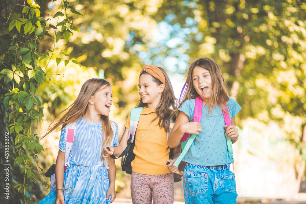  Happy kids. Three little girls walking trough park.