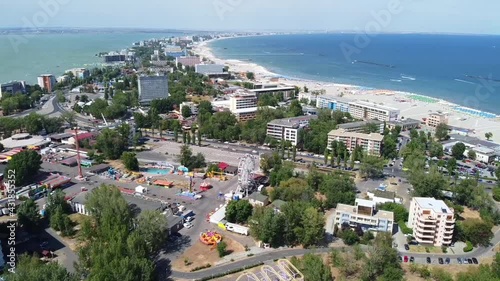 Aerial drone footage on the Black Sea coast ,flying over the riviera of Mamaia resort area and Mamaia lake  in Constanta City , Romania, a top travel destination , summer season photo