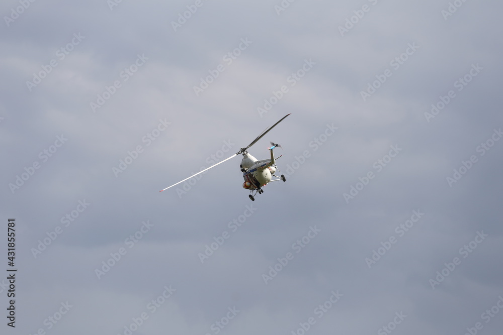 Helikopter policyjny w akcji poszukiwawczej na niebie.   - obrazy, fototapety, plakaty 