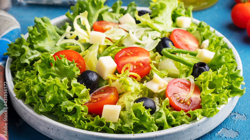 Diet and healthy salad with lettuce, tomatoes, cheese, black olives and onion. Closeup Diet and healthy salad with lettuce, tomatoes, cheese, black olives and onion. Closeup