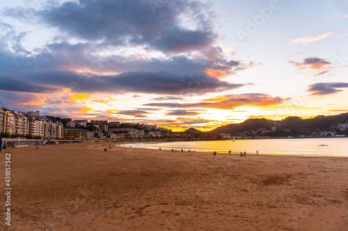 Orange sunset on the beautiful beach of La Concha in the city of San Sebastian, in the province of Gipuzkoa in the Basque Country photo