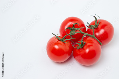Tomatoes on a vine on a white background. Fresh and healthy vegetable. Ripe and juicy tomato
