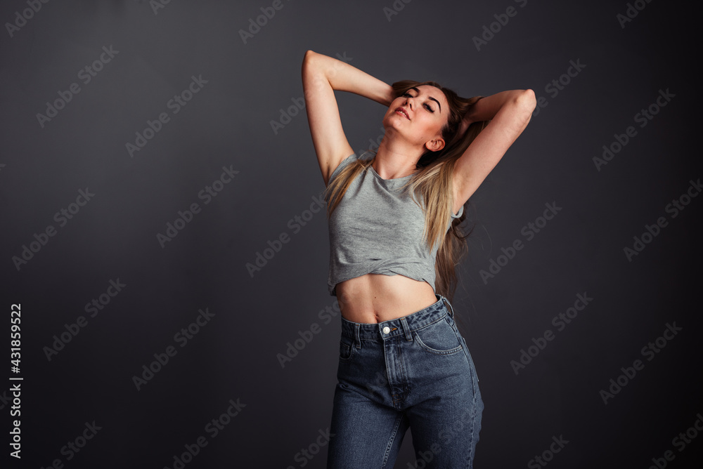 A girl with long hair looks stretched up on a gray background without retouching. A girl with long hair looks stretched up on a gray background without retouching.