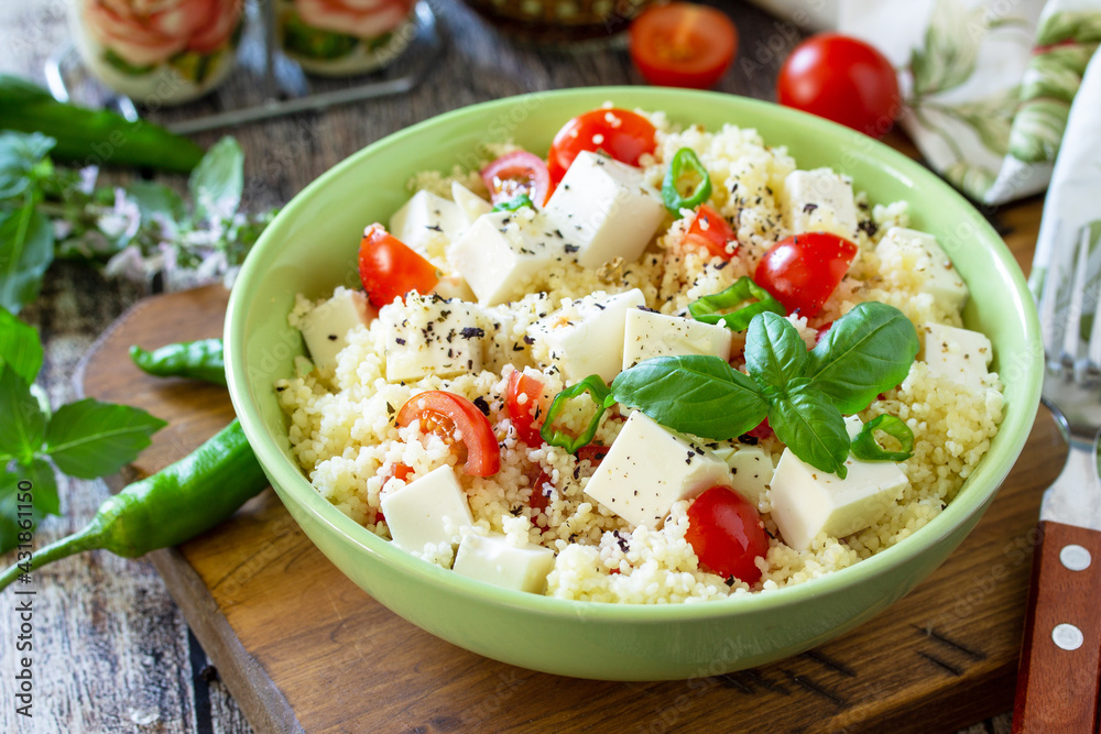 Food dieting concept, tabbouleh salad. Couscous salad with feta cheese, tomatoes, basil and chili on a rustic wooden table. Food dieting concept, tabbouleh salad. Couscous salad with feta cheese, tomatoes, basil and chili on a rustic wooden table.