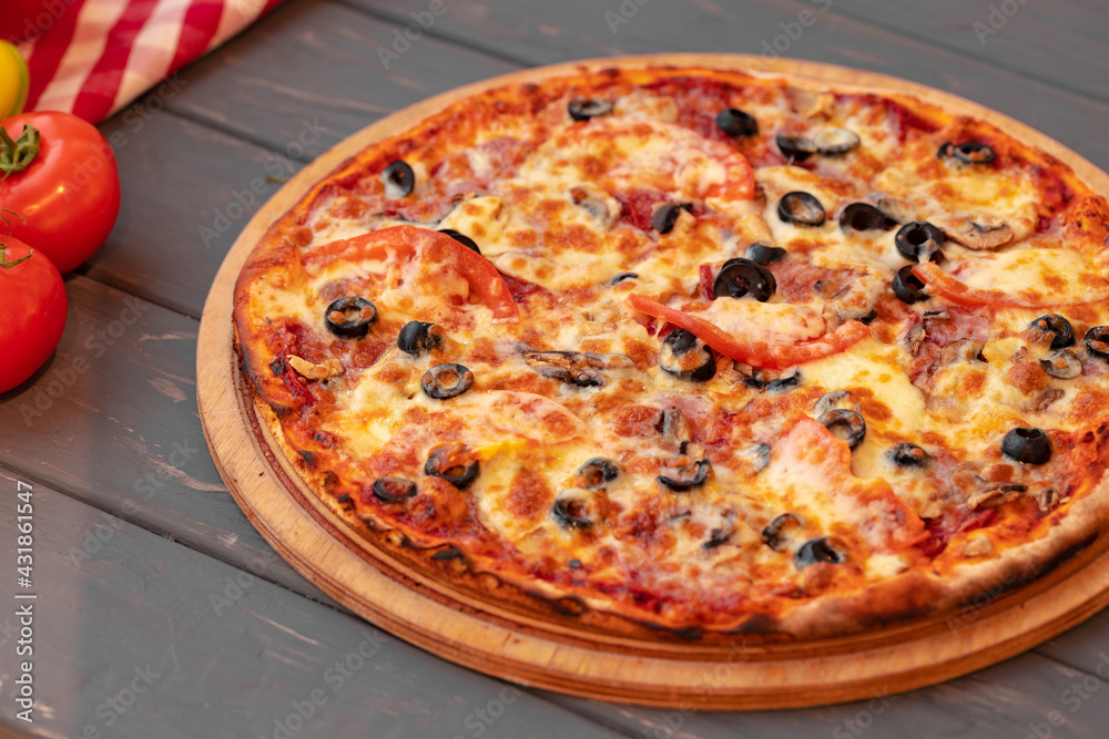 Close up of freshly baked pizza on black wooden table