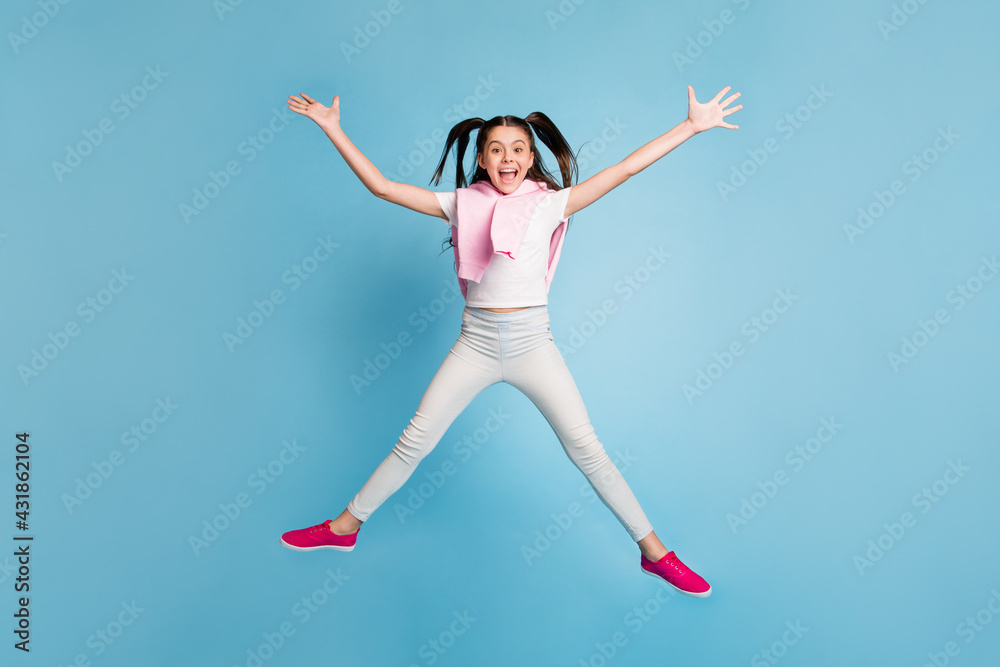 Full length body size view of attractive cheerful girl jumping having fun isolated over bright blue color background Full length body size view of attractive cheerful girl jumping having fun isolated over bright blue color background