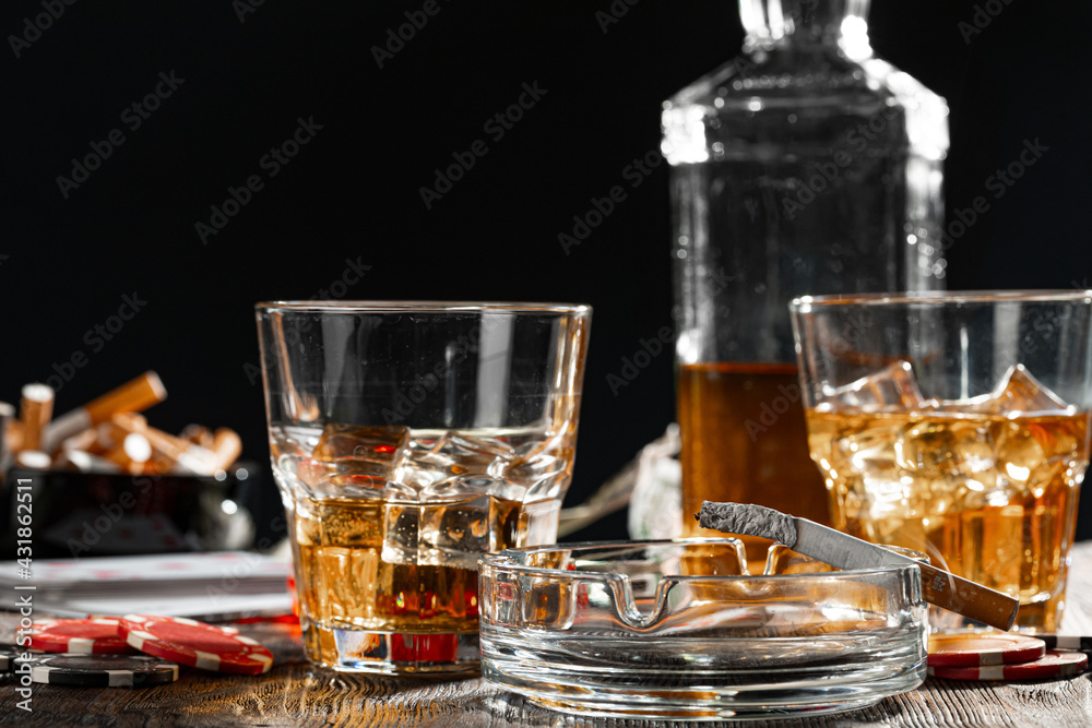Playing poker with whiskey and cigars on table Playing poker with whiskey and cigars on table
