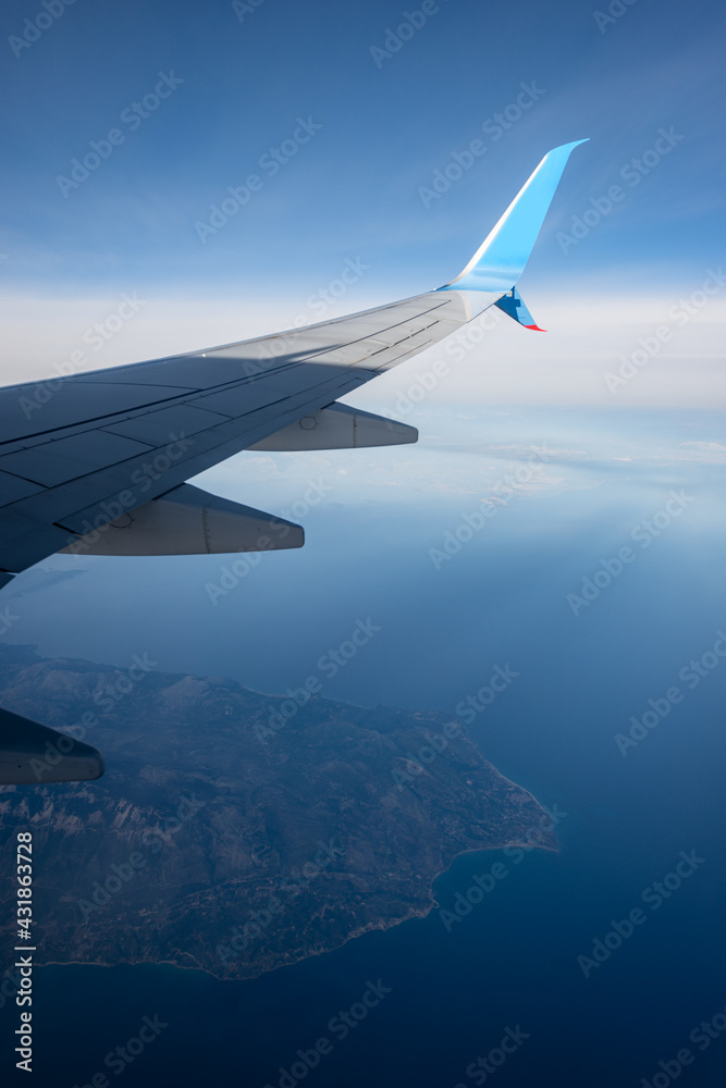 Commercial airplane flying over the Greek Islands of the Mediterranean sea, Looking through the plane window. Commercial airplane flying over the Greek Islands of the Mediterranean sea, Looking through the plane window.