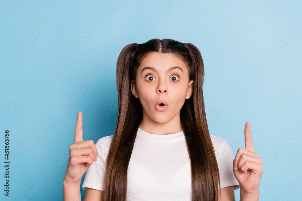 Portrait of attractive amazed long-haired girl pout lips pointing forefingers up copy space isolated over bright blue color background