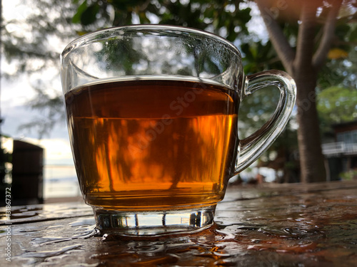 Black Tea on the beachside table with sea background, nature light. Thailand