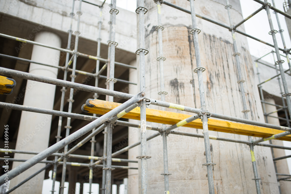 Fototapeta premium Close-up of scaffolding against the background of reinforced concrete supports of the transport bridge