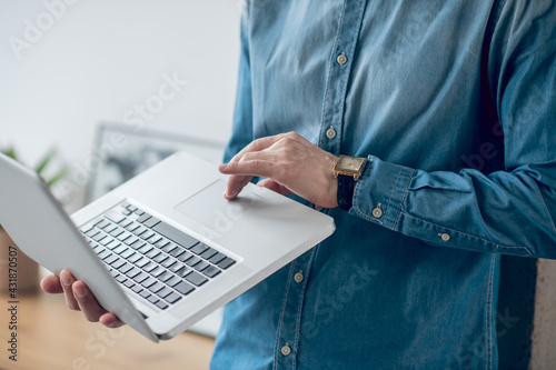 Close up picture of mans hands holding a laptop